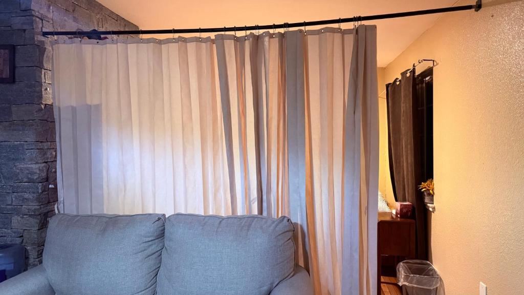 een slaapkamer met een wit gordijn en een bank bij Cozy House Nested Around Trees E in San Jose