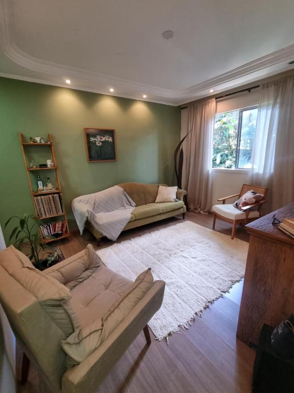 un soggiorno con divano, tavolo e divano di Jasmim 12 a Santo André