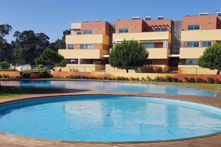 a large swimming pool in front of a building at Furadouro pine beach apartment in Ovar