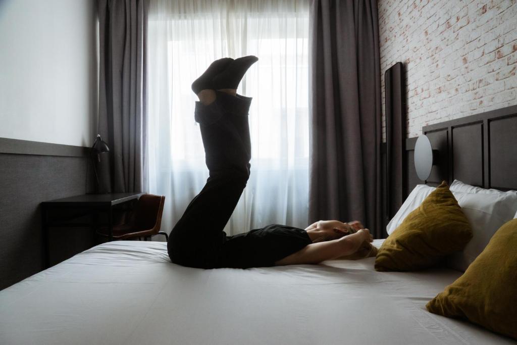 a woman laying on a bed with her legs in the air at BYPILLOW San Mamés in Bilbao