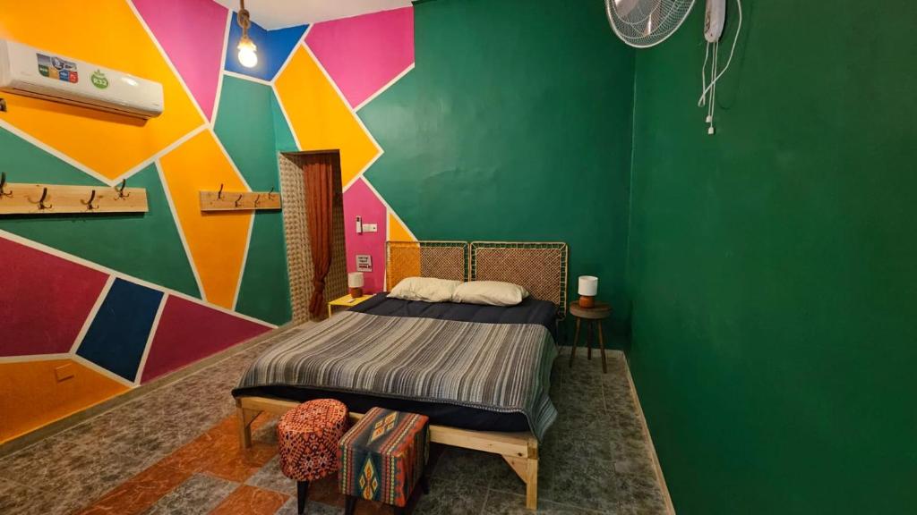 - une chambre avec un lit et un mur coloré dans l'établissement Mango Haus, à Aqaba