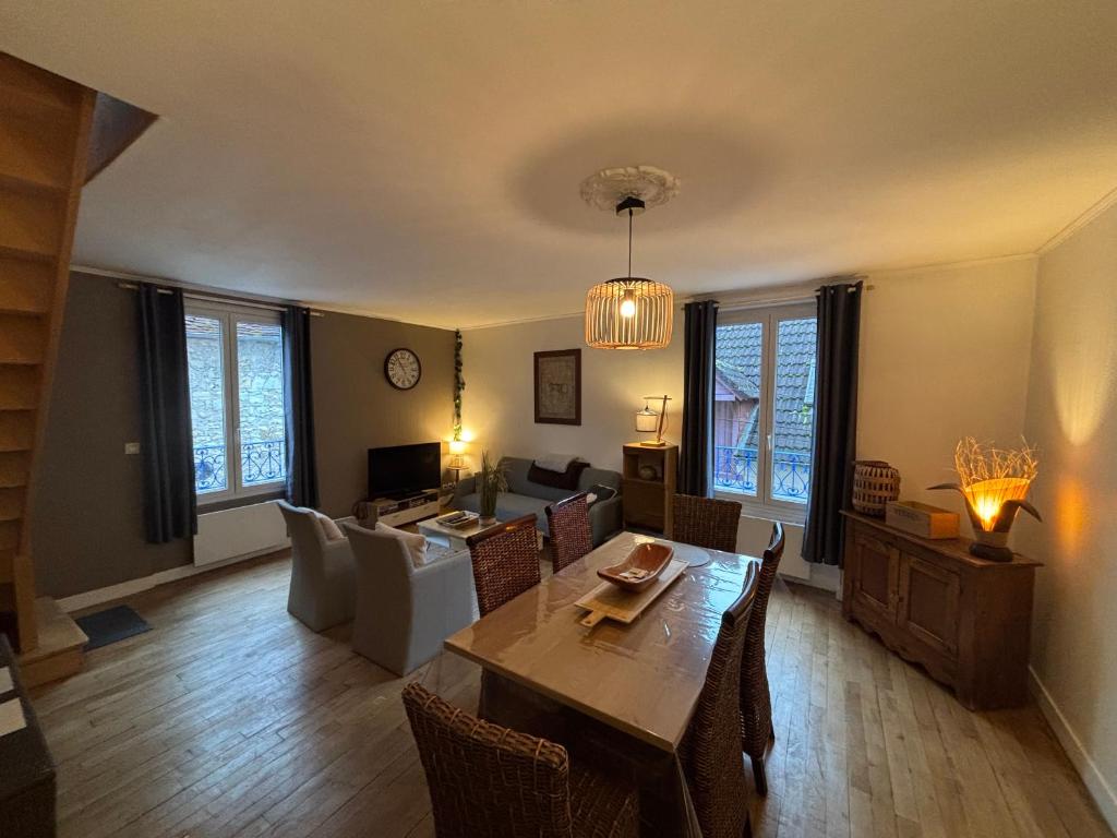 een woonkamer met een tafel en een bank bij Gîte du Palais 3 étoiles in Châteauneuf-sur-Cher