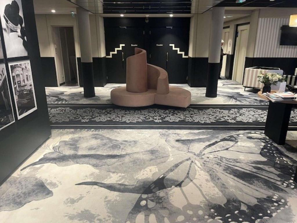 a lobby with a bench in the middle of a building at Mercure Granville Le Grand Large in Granville