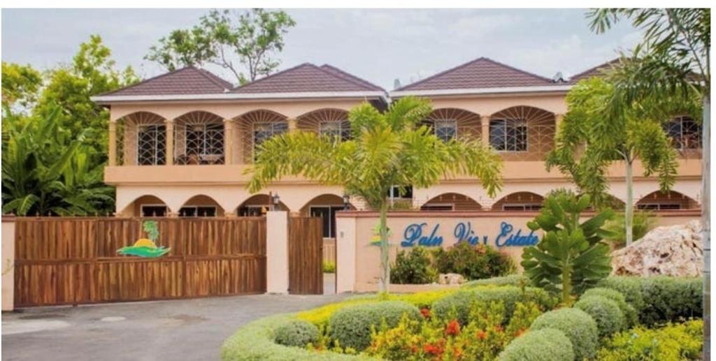 een huis met een hek ervoor bij Ubuntu De La Villa- Palm View Estate in Mammee Bay