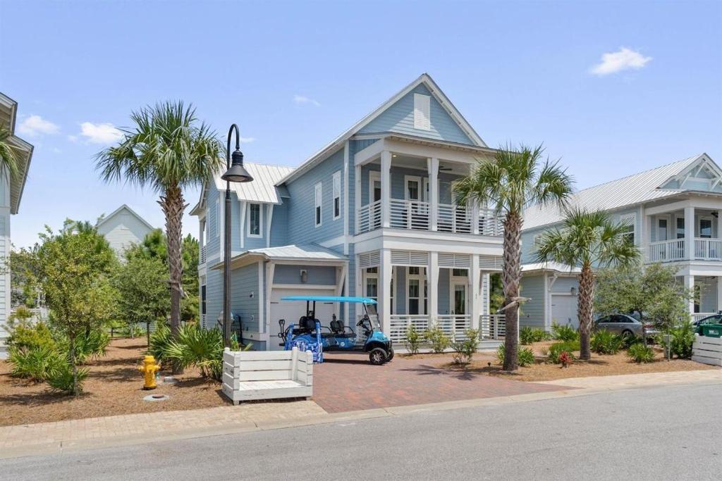 a blue house with a golf cart in front of it at Sunset Key in Inlet Beach