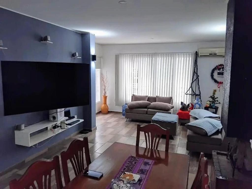 ein Wohnzimmer mit einem großen Flachbildfernseher in der Unterkunft Hosteria TDT in Mar del Plata