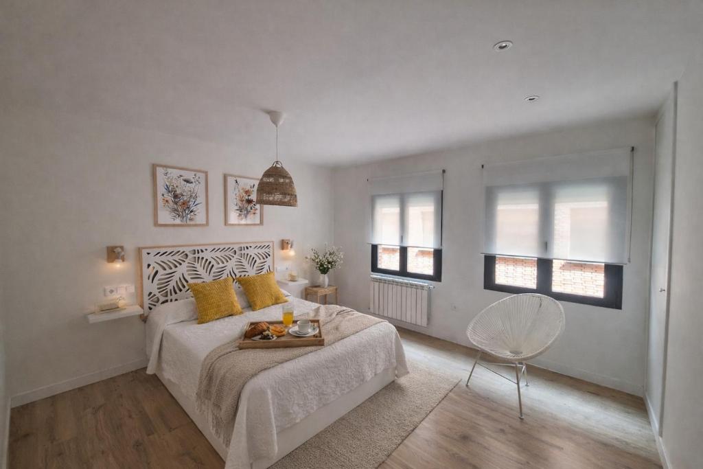 ein weißes Schlafzimmer mit einem Bett und einem Tisch in der Unterkunft Apartamento Premium PLAZA MAYOR con PARKING in Avila