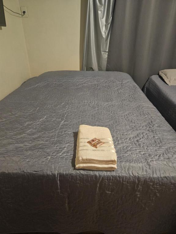 - un lit avec une couverture et une serviette dans l'établissement morada da felicidade, à São Gabriel