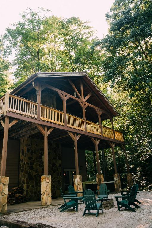 a large log cabin with a deck and chairs at Creekside Oasis! in Stanton