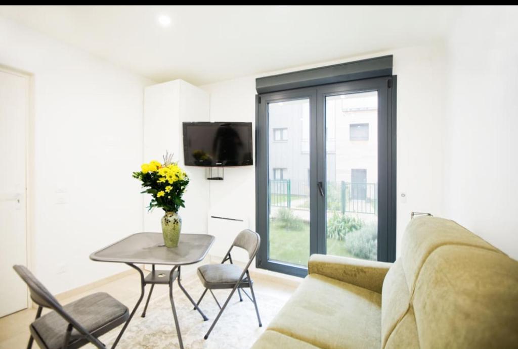 a living room with a couch and a table at Paris sud studio cosy in Arcueil