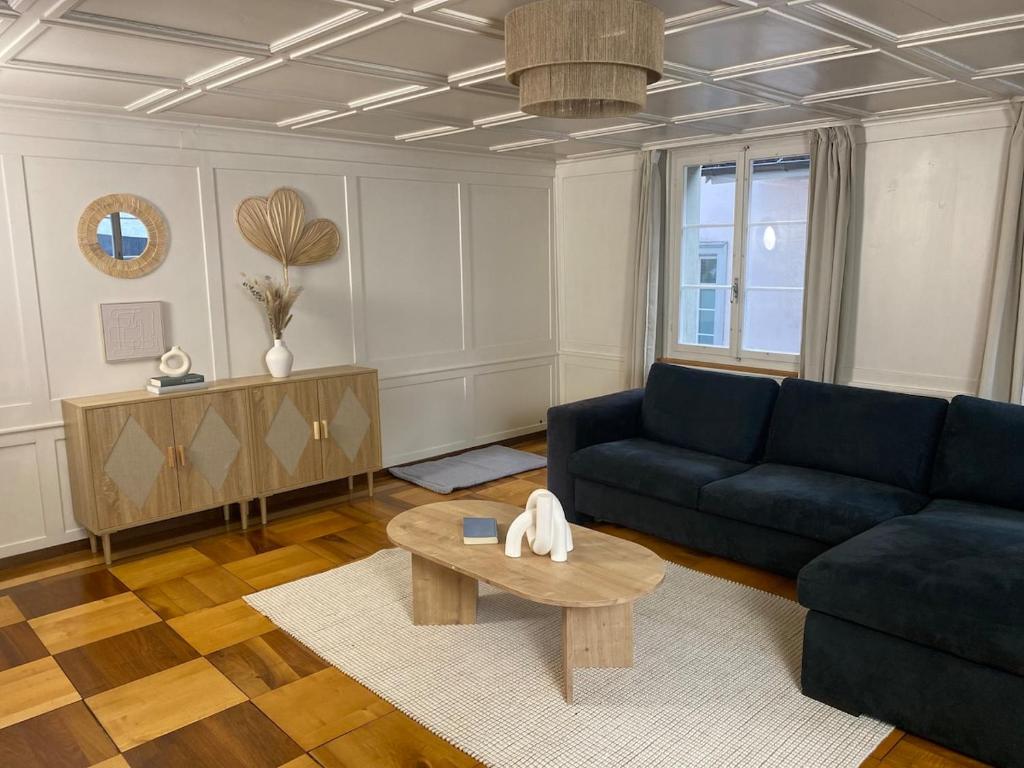 a living room with a blue couch and a table at Cara Nima Schwyz in Schwyz