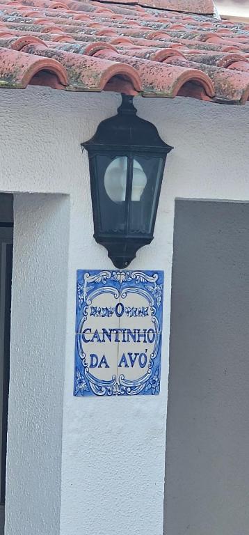 un cartello sul lato di un edificio con un lampione di O Cantinho da Avó ad Azeitao