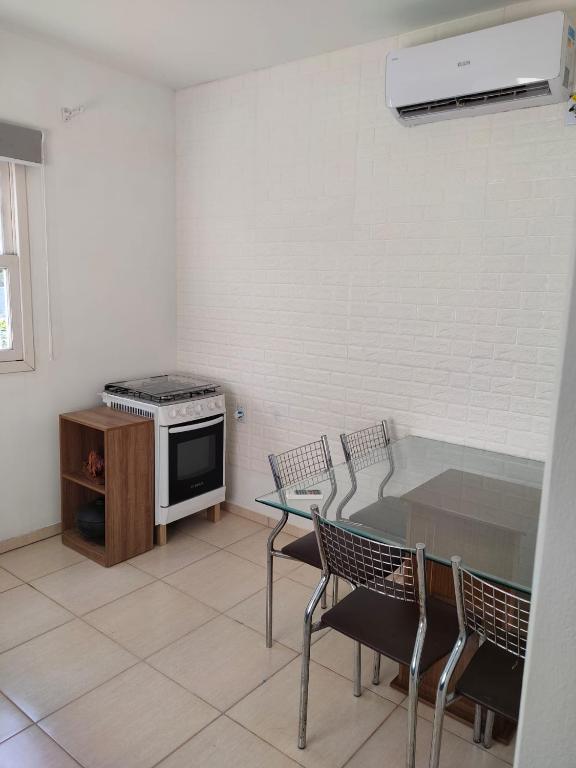 a kitchen with a table and chairs and a stove at Kitnet no Morro dos Conventos in Araranguá