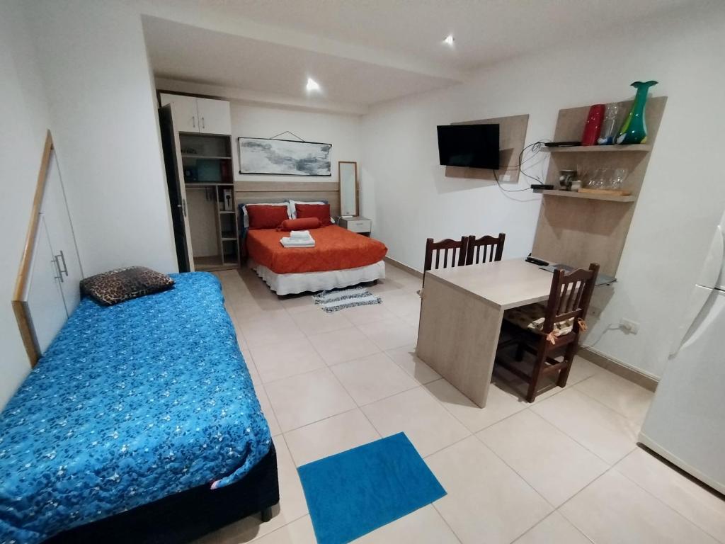 ein Schlafzimmer mit einem Bett, einem Schreibtisch und einem Tisch in der Unterkunft Refugio Sureño departamento completo centrico wifi in Ushuaia