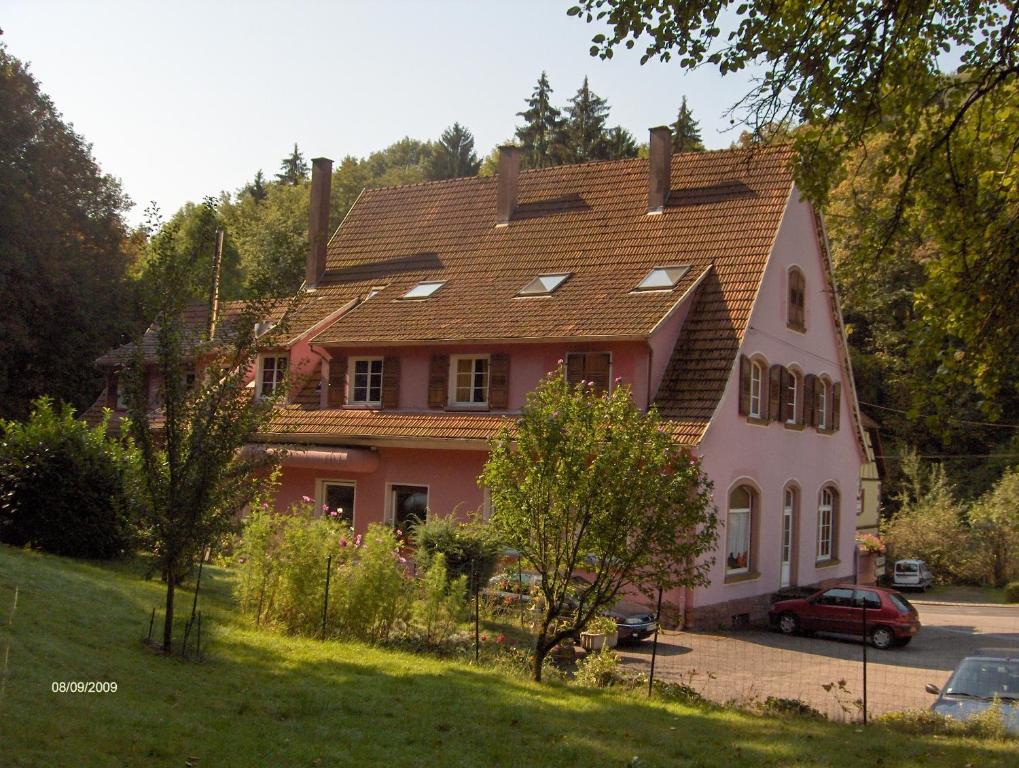 ein großes rosafarbenes Haus mit rotem Dach in der Unterkunft Hotel-Restaurant du Windstein in Windstein