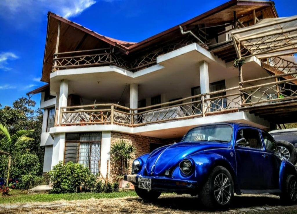 an old blue car parked in front of a house at Mindo Suites in Mindo