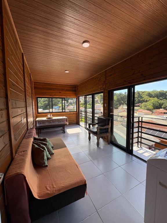 a large room with a bed and large windows at Cobertura Vista mar com churrasqueira in Governador Celso Ramos