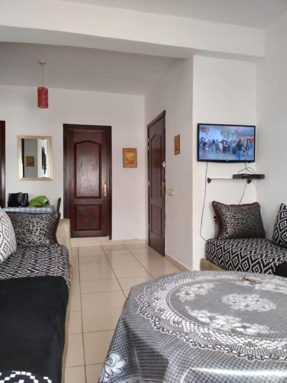 een kamer met een bed, een bank en een tv bij Private Room near Mohammed V - Marrakech in Marrakesh