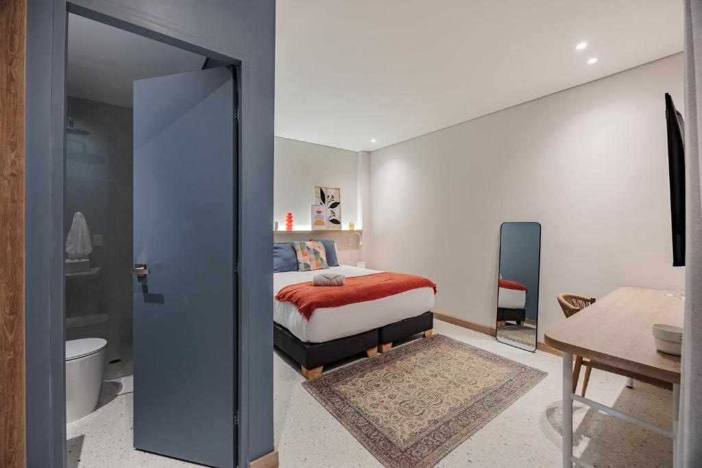 een slaapkamer met een bed en een badkamer bij Medellinn The Blooming Hotel in Medellín