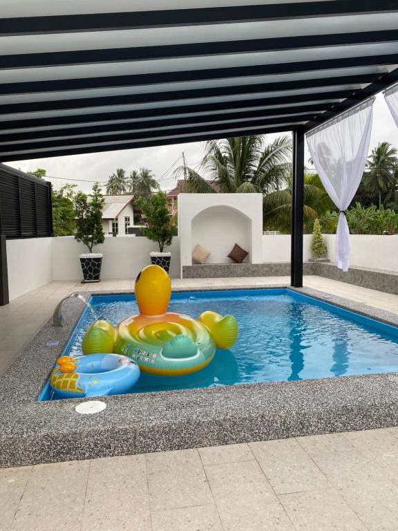 a swimming pool with a inflatable pool toy in a house at RusanHome Pengkalan Chepa in Pengkalan Cepa