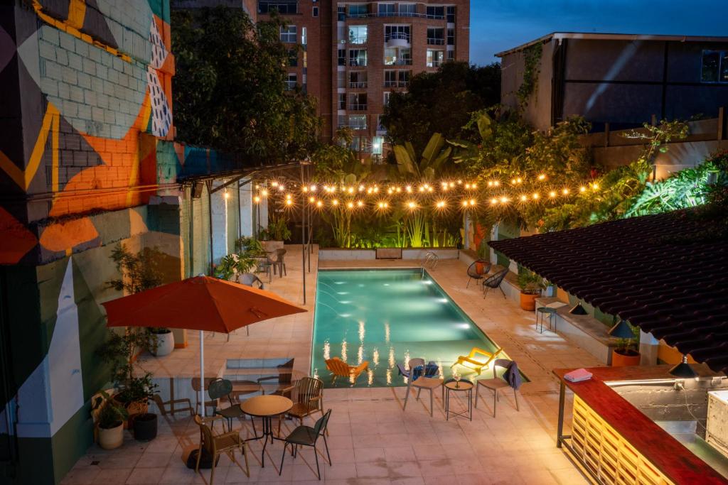 an overhead view of a pool with tables and chairs at Medellinn The Blooming Hotel in Medellín