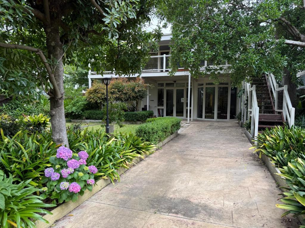 una casa con fiori rosa e un passaggio pedonale di Entire Beachfront Vacation House a McCrae