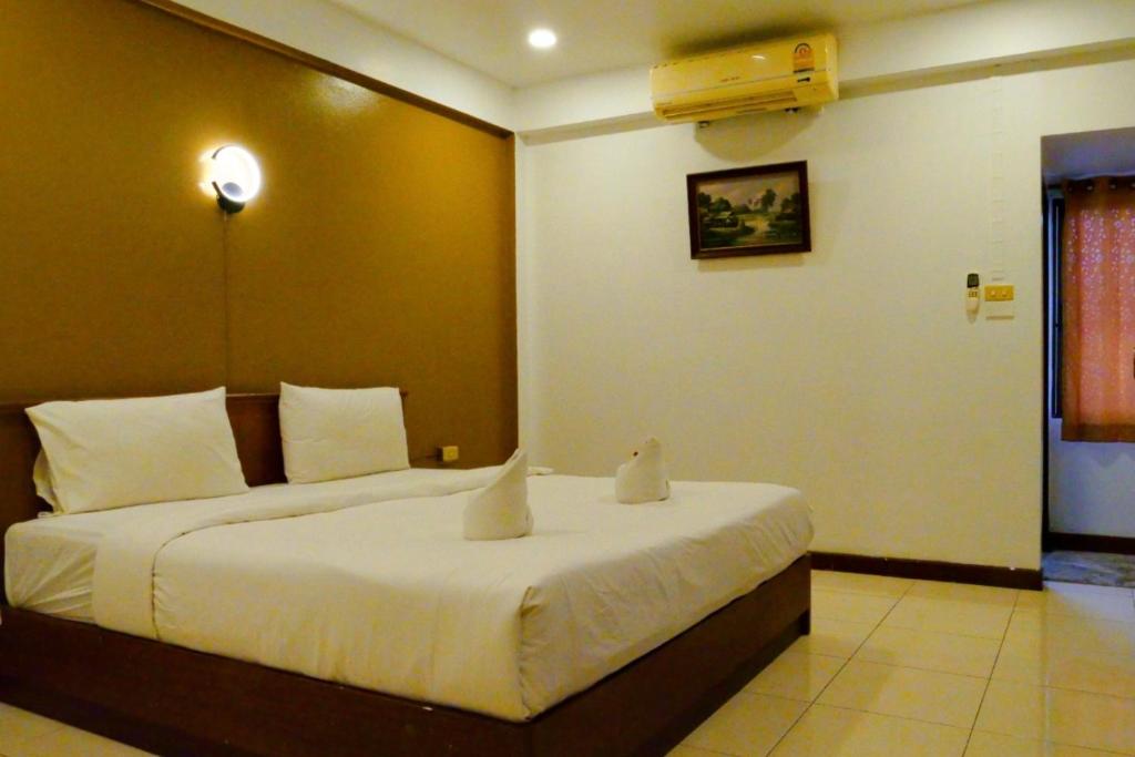 A bright bedroom with a large bed and wall-mounted air conditioner.