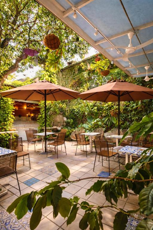 a patio with tables and chairs and umbrellas at Casa de Pinos Hotel Boutique in Bucaramanga