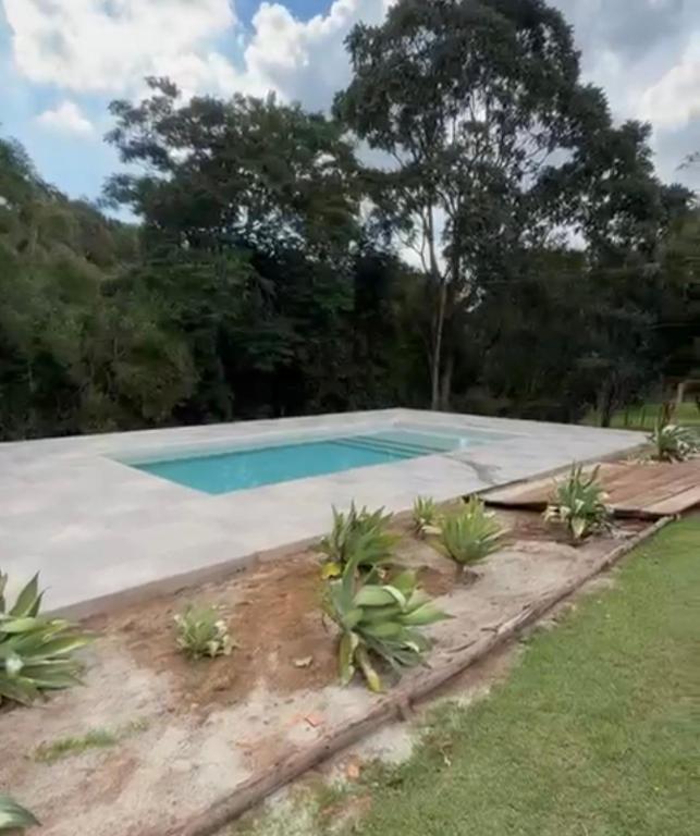 a swimming pool in a yard with trees at Recanto das Onças in Extrema
