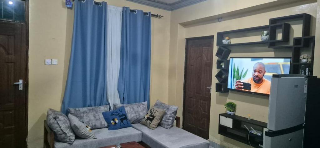 un salon avec un canapé et une télévision à écran plat dans l'établissement Marially Luxury 4, à Malindi