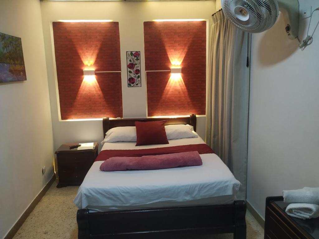 ein Schlafzimmer mit einem Bett mit zwei Lichtern an der Wand in der Unterkunft Hotel Ejecutivo in Pereira