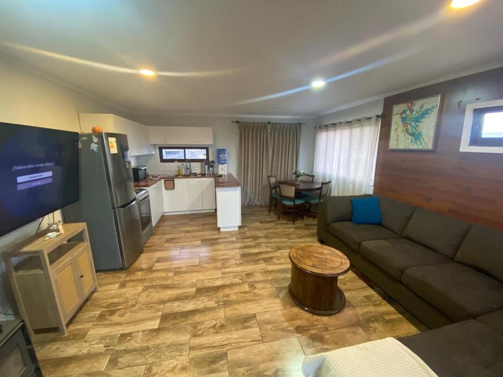 een woonkamer met een bank en een keuken bij Great house in Punta de Lobos in Chacurra