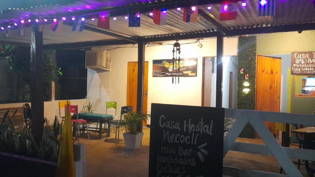 een terras met een restaurant, voorzien van een uithangbord en verlichting bij Casa Hostel Necoclí Playa Brisa y Mar in Necoclí