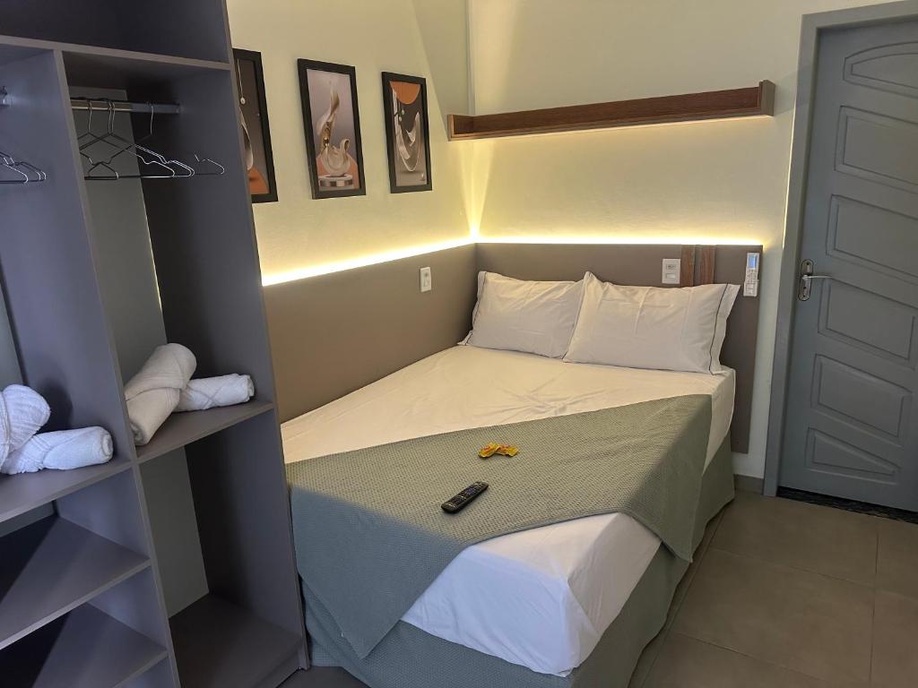 a small room with a bed with a remote control on it at Pousada Lehmen in Santarém