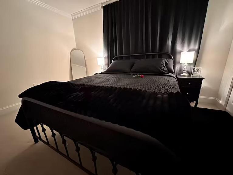 ein Schlafzimmer mit einem großen Bett mit schwarzer Bettdecke in der Unterkunft Hotness in Chandernagore Settlement