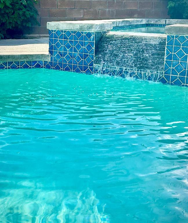 a pool of blue water next to a brick wall at Desert Vista View in Desert Hot Springs