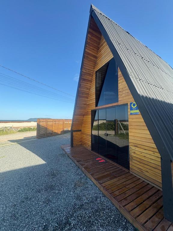 a small wooden building with a pitched roof at Chalé Rosa dos Ventos in Itapoa