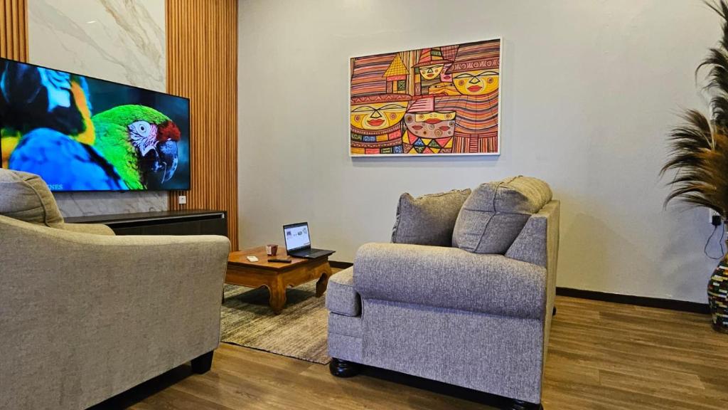 un soggiorno con due sedie e una TV a schermo piatto di The Blue Donkey a Paramaribo