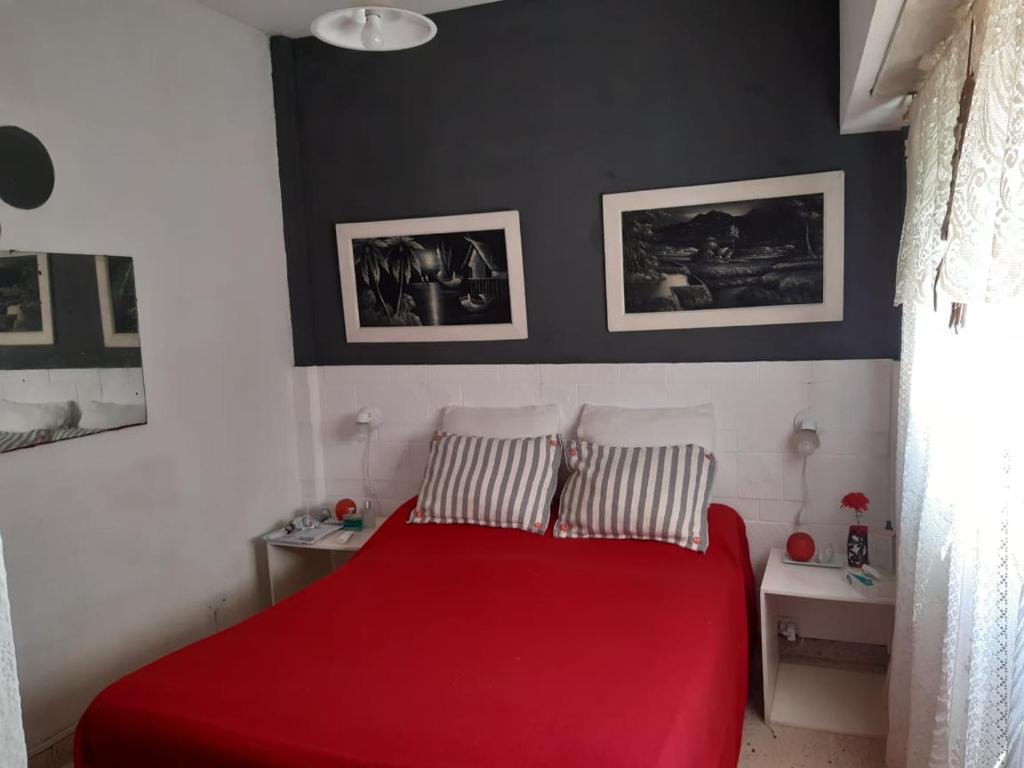 un letto rosso in una camera da letto con due cuscini di Marbella 1 a San Bernardo