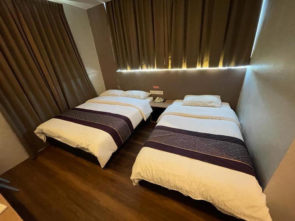 una stanza con due letti in una stanza di Super 8 Hotel @ Bayan Baru a Bayan Lepas