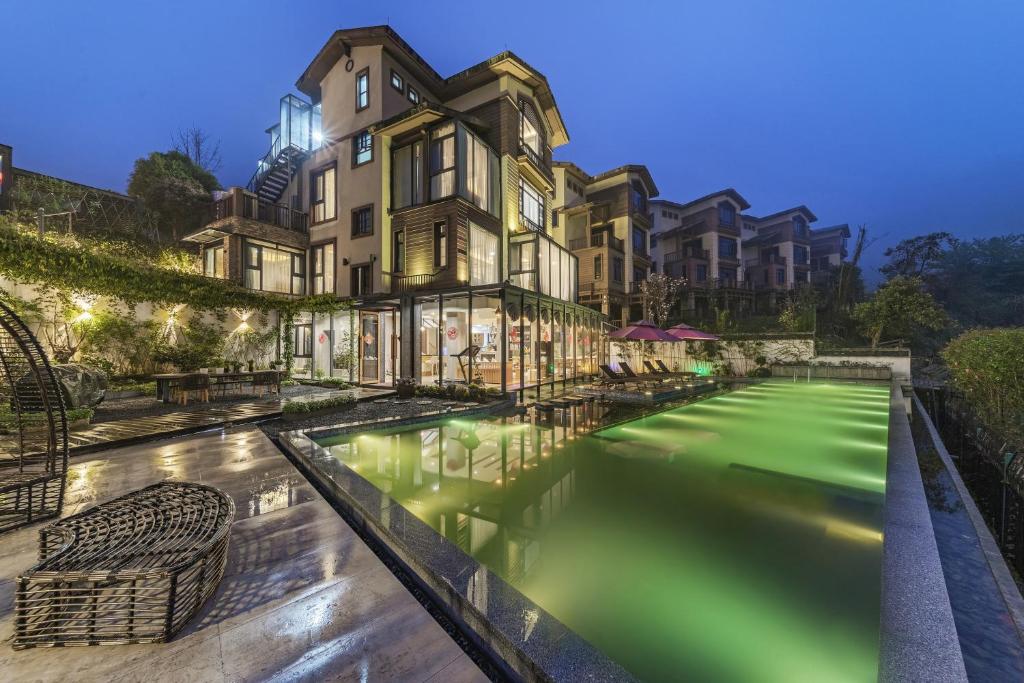a swimming pool with green water in front of a building at Zhangjiajie Lake View Hotel-Free airport pick-up in Zhangjiajie