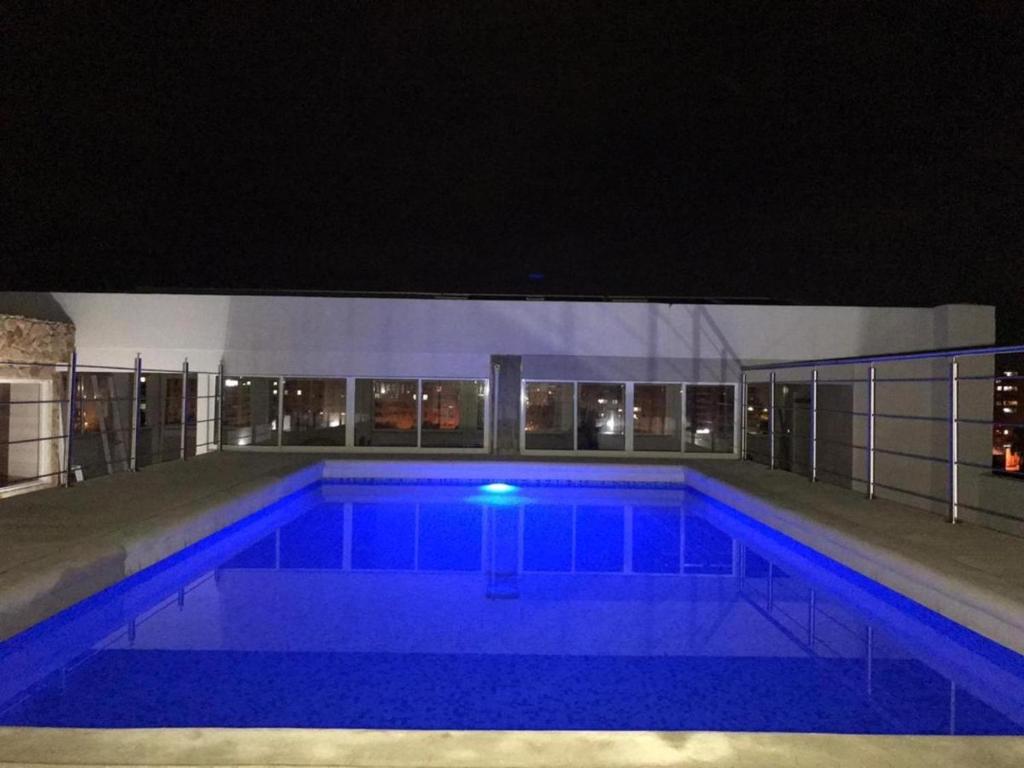 a large swimming pool at night with blue lights at Luxury apartment with pool view and Jacuzzi in Cali