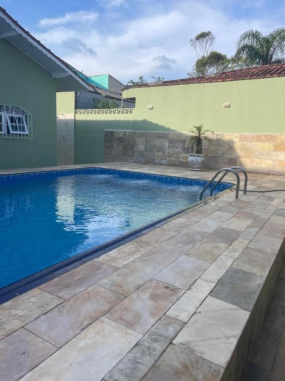 a swimming pool in front of a house at Bela casa com piscina in Mongaguá