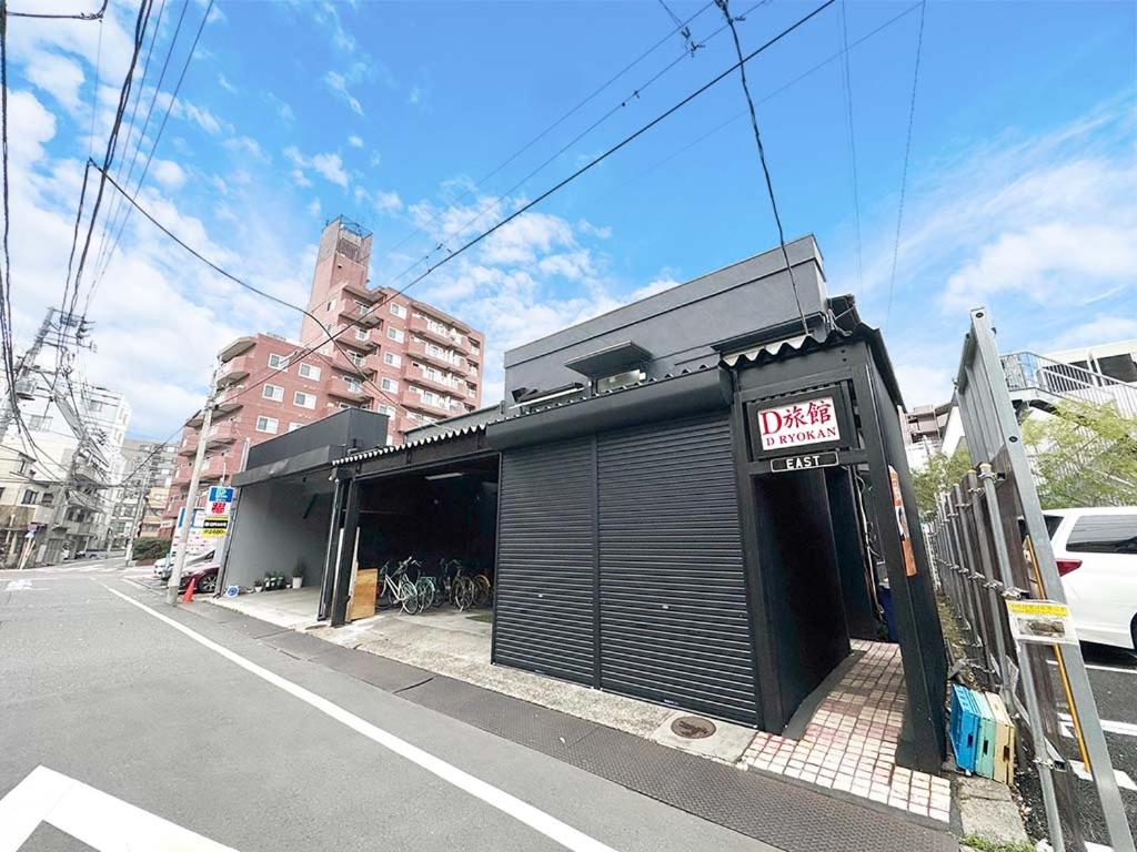 a black building with a sign on it on a street at D旅館　Dryokan in Tokyo