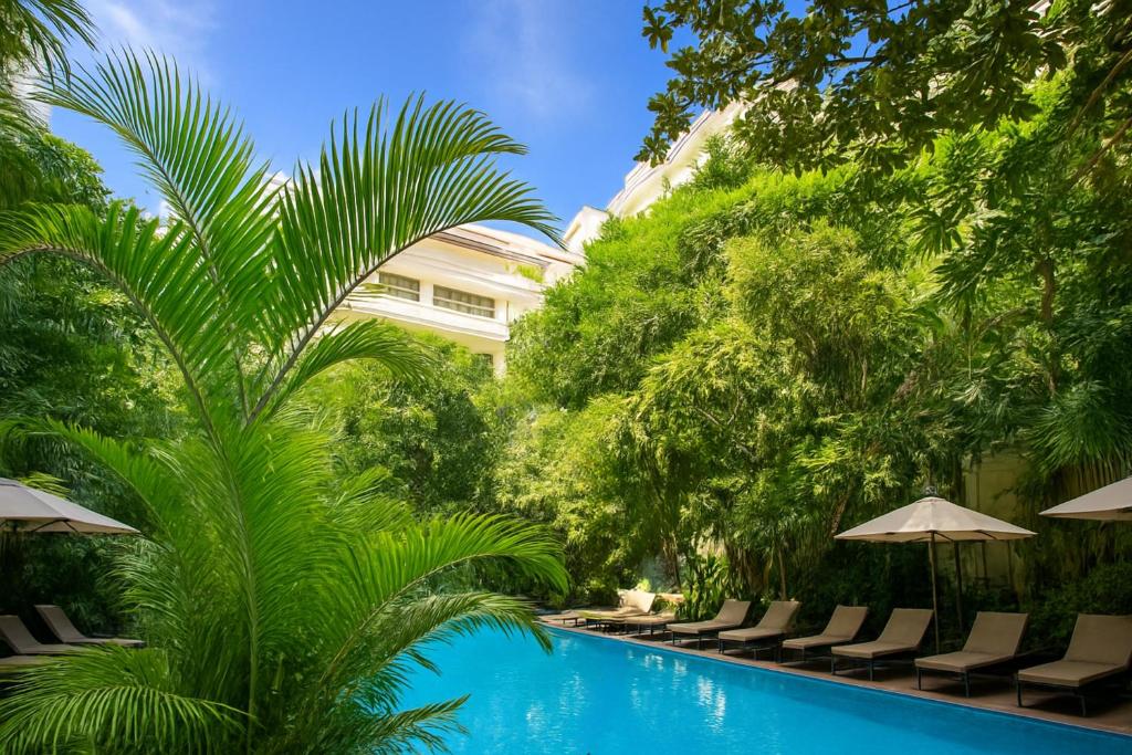 een zwembad in het resort met stoelen en bomen bij Golden Citadel Hotel Siem Reap in Siem Reap