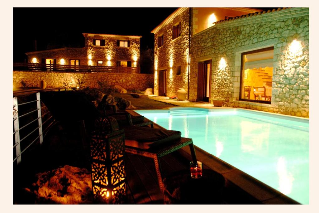a swimming pool in front of a building at night at Villa Danae in Meganisi