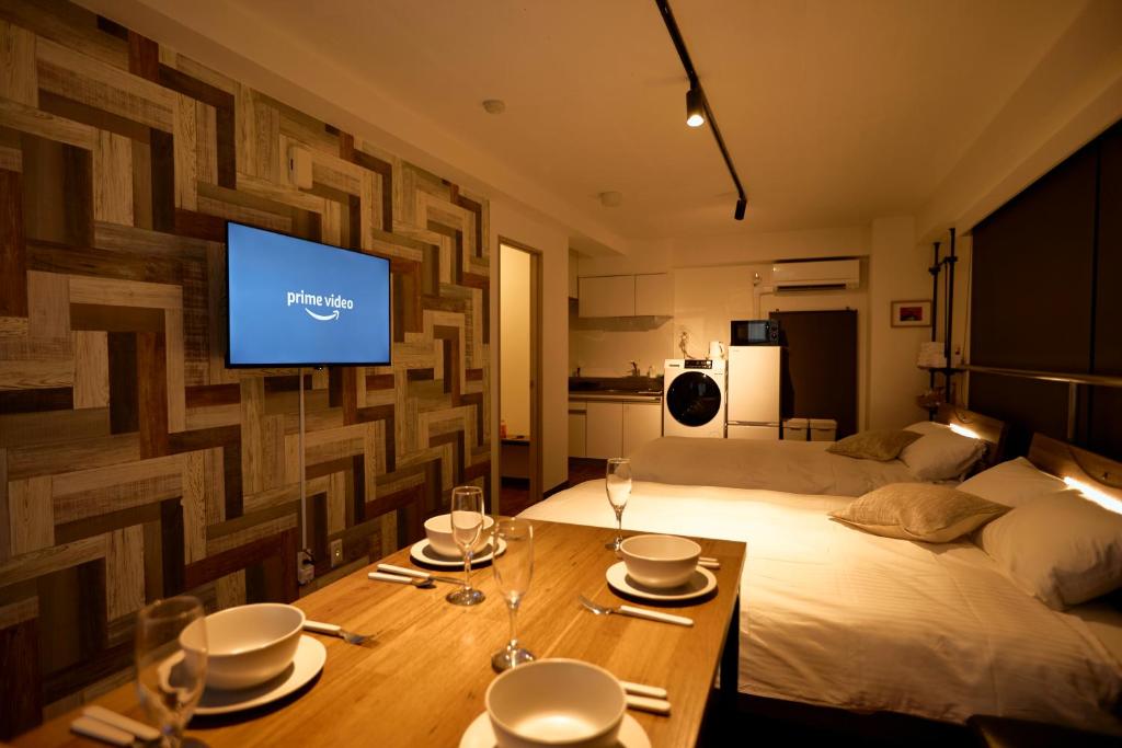 een kamer met een bed met een tafel en een televisie bij KAMINARI Inn Newly Renovated Jan 2026 in Tokyo