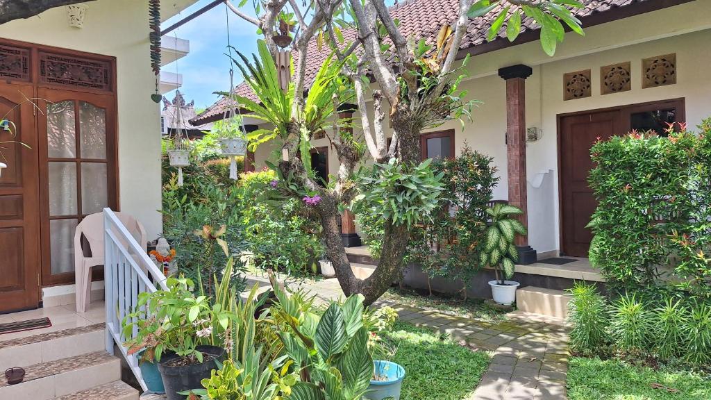 a house with a lot of plants in the yard at Jepun Bali Homestay Sanur in Sanur
