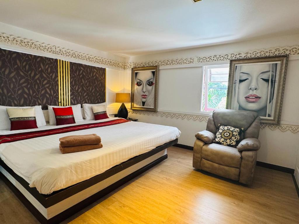 une chambre avec un grand lit et une chaise dans l'établissement Baipho Lifestyle, à Patong Beach