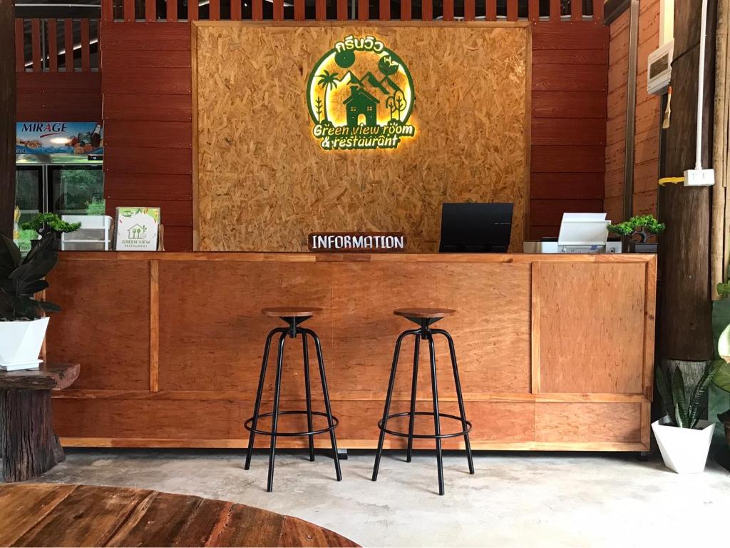 a wooden counter with two bar stools in front of access at Greenview Room and Restaurant in Ko Yao Yai